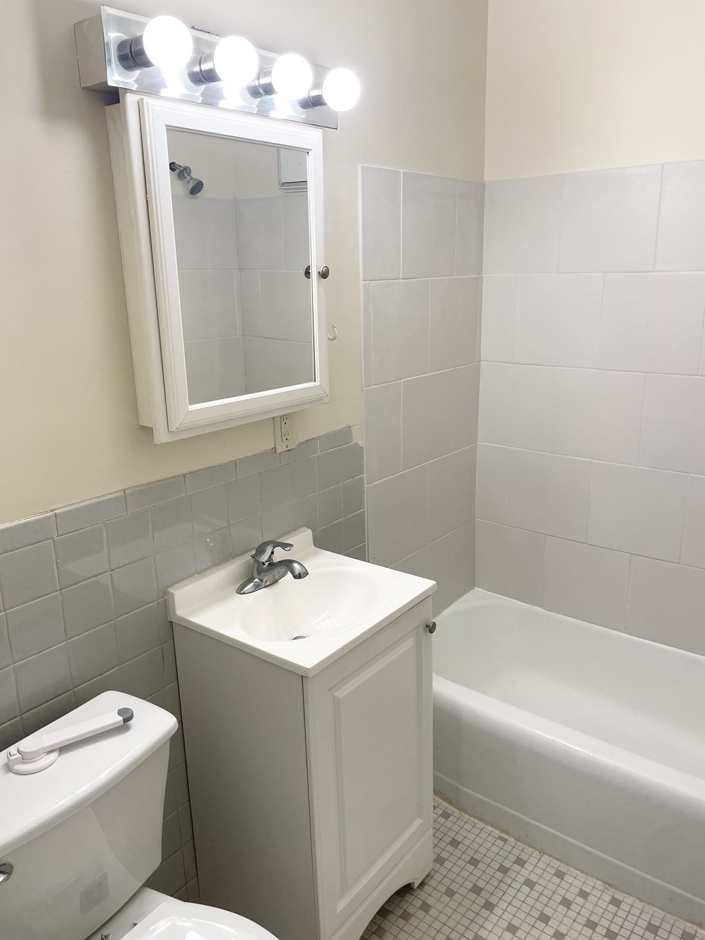 A white bathroom with a toilet, sink, and tub.