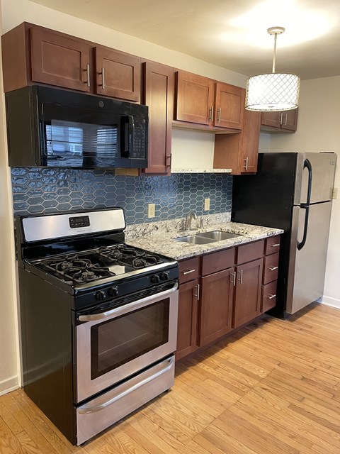 Updated kitchen with granite countertops, decorative backsplash tile and stainless steel appliances.