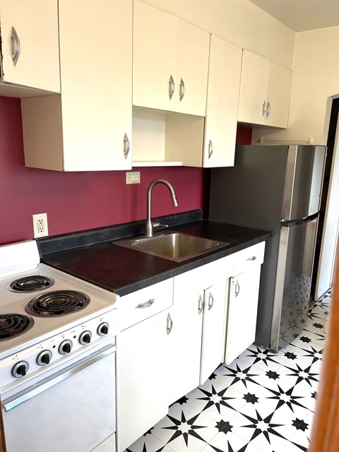 Updated kitchen with new countertop, sink, faucet, and flooring.