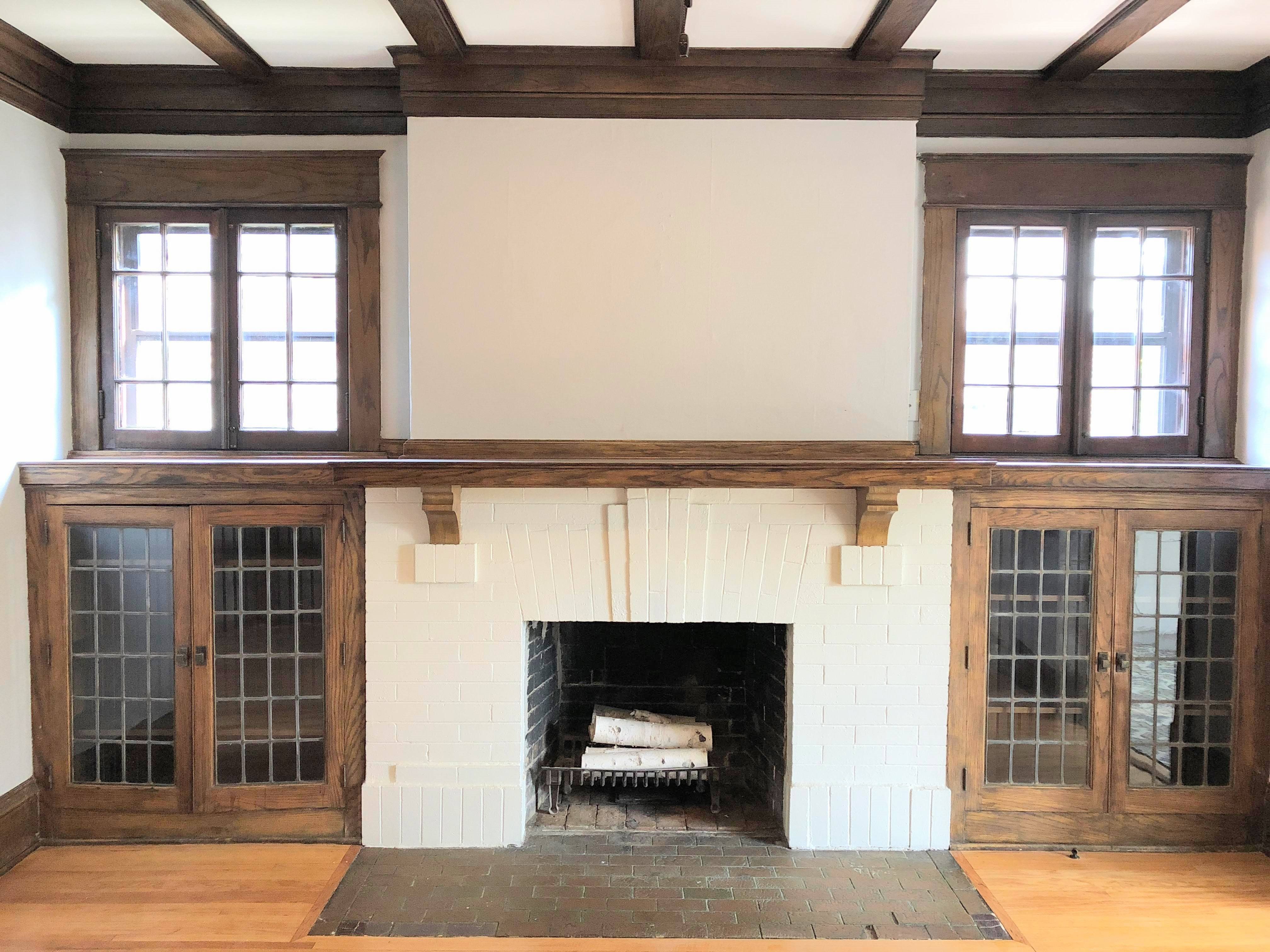 A fireplace with a white mantle and a wooden frame is in the center of the room.