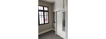 A white door is open to a room with a grey carpet.