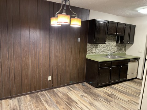 A kitchen with wooden cabinets and a sink.