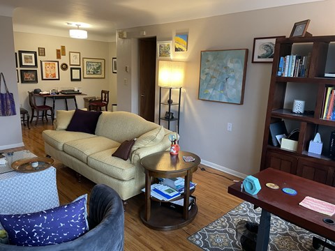 A living room with a tan couch and a grey chair.