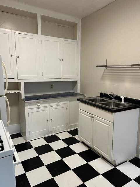 A kitchen with black and white checkered floor.
