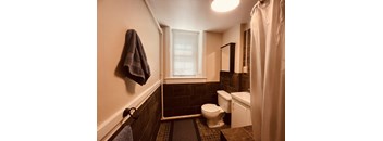 A bathroom with a toilet, sink, and shower.