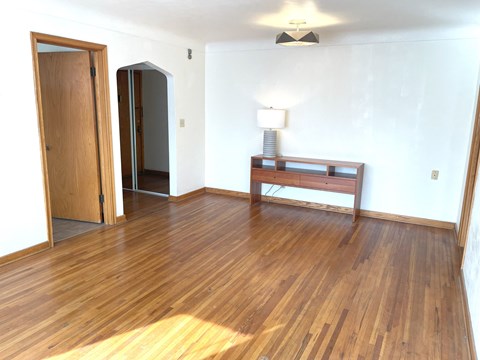 A room with wooden floors and a wooden bench.