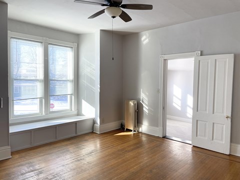 A room with a ceiling fan and a radiator on the floor.
