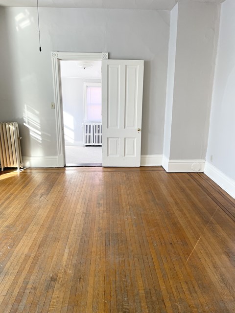 A room with a wooden floor and white walls.
