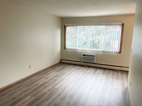 A room with a window and a wall-mounted air conditioner.