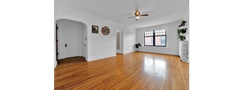 A room with a wooden floor and a ceiling fan.