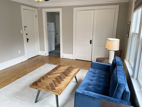 A living room with a blue couch and a wooden coffee table.