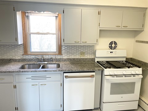 A kitchen with white appliances and cabinets.