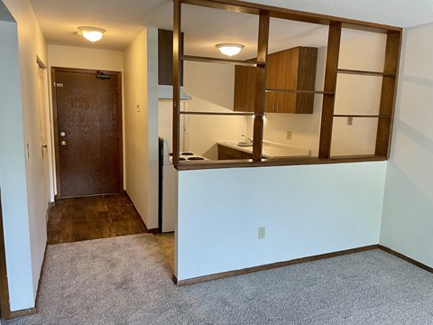A room with a brown door and a white wall.