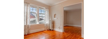 A room with a window and a radiator on the floor.