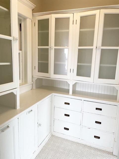 A kitchen with white cabinets and drawers.