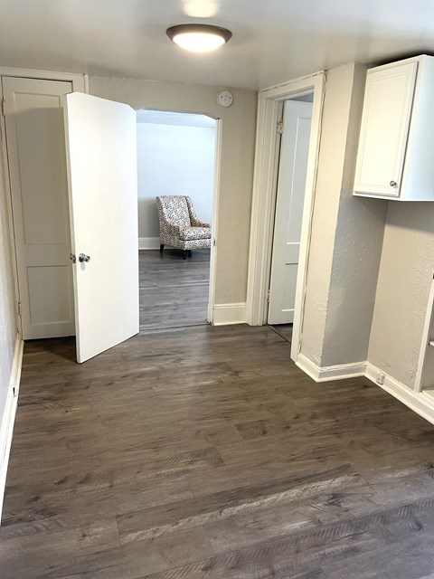 A room with white doors and a grey chair.