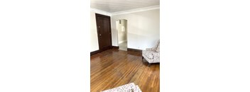 A room with a wooden floor and a chair.