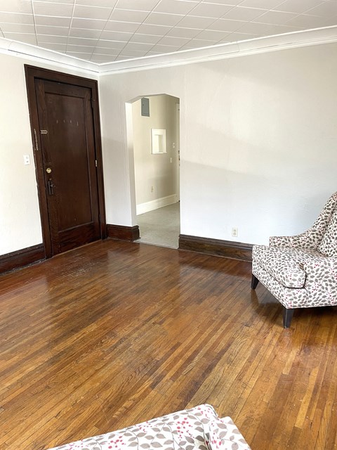 A room with a wooden floor and a chair.
