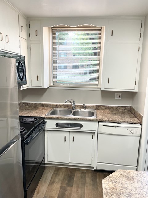 A kitchen with white cabinets and a black stove top oven.