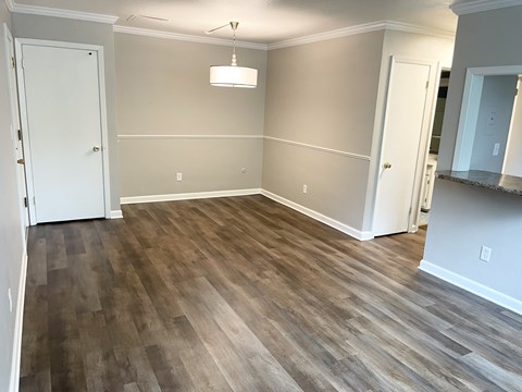 A room with wood flooring and white walls.