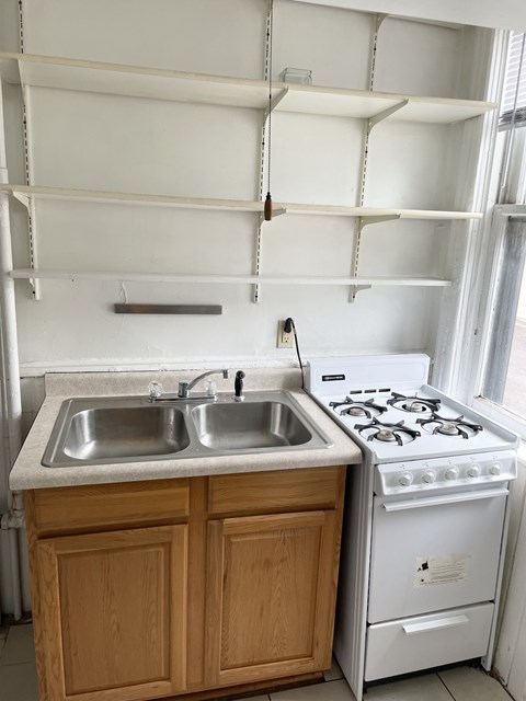 A kitchen with a white stove and a sink.