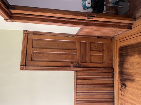 A wooden cabinet with a drawer and a door.