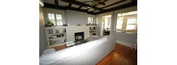A living room with a fireplace and a white couch.