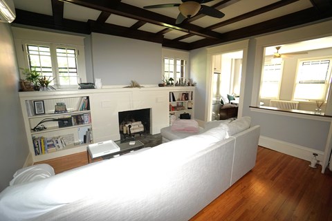 A living room with a fireplace and a white couch.