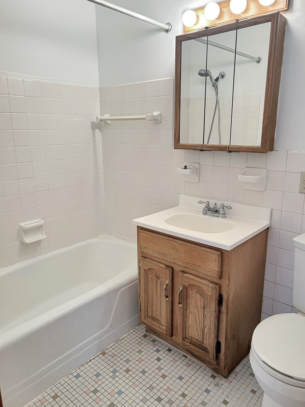 A white sink is on a wooden cabinet in a bathroom.
