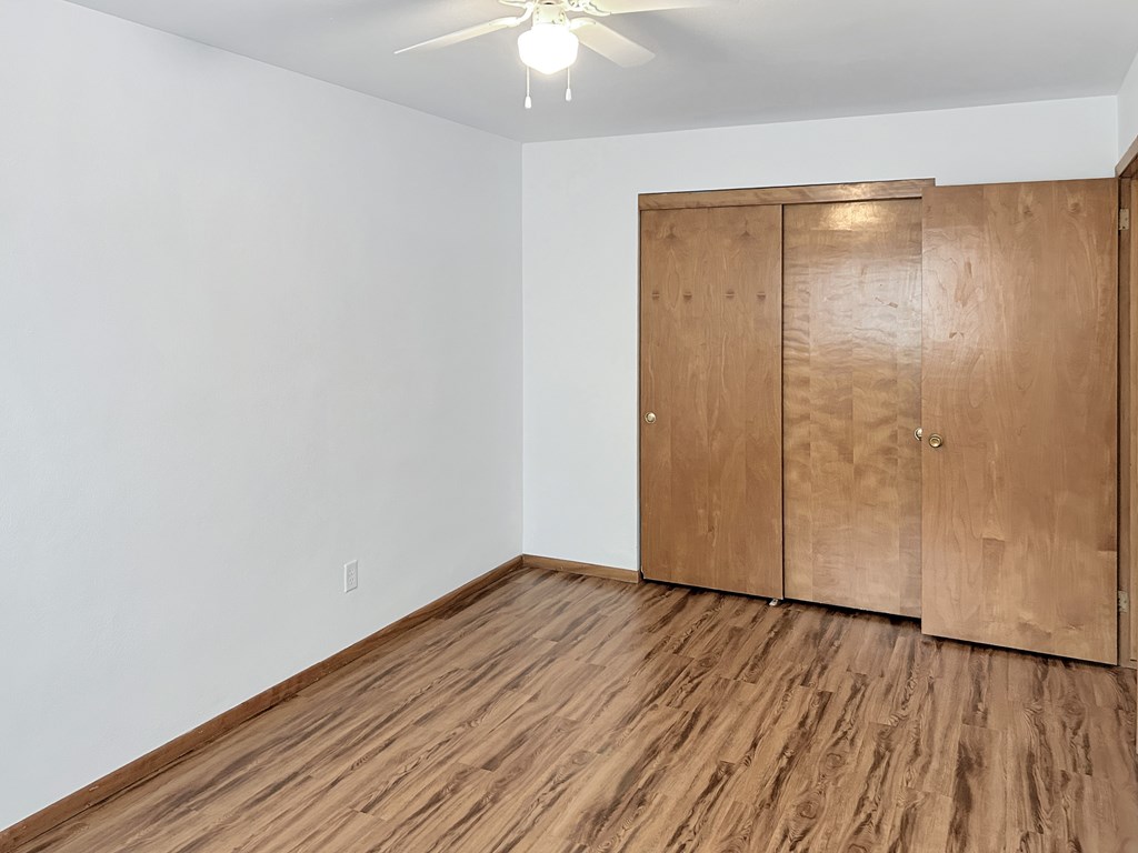 A room with a wooden floor and a wooden wardrobe.