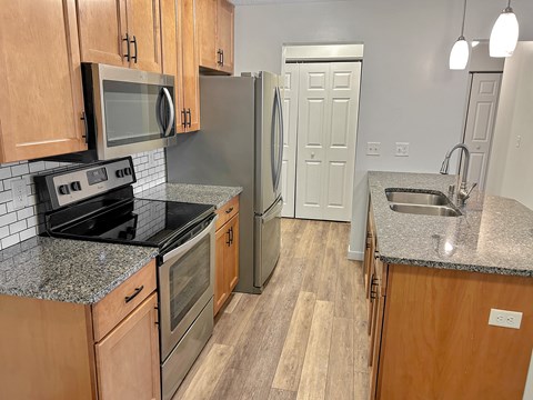 A kitchen with wooden cabinets and a granite countertop.