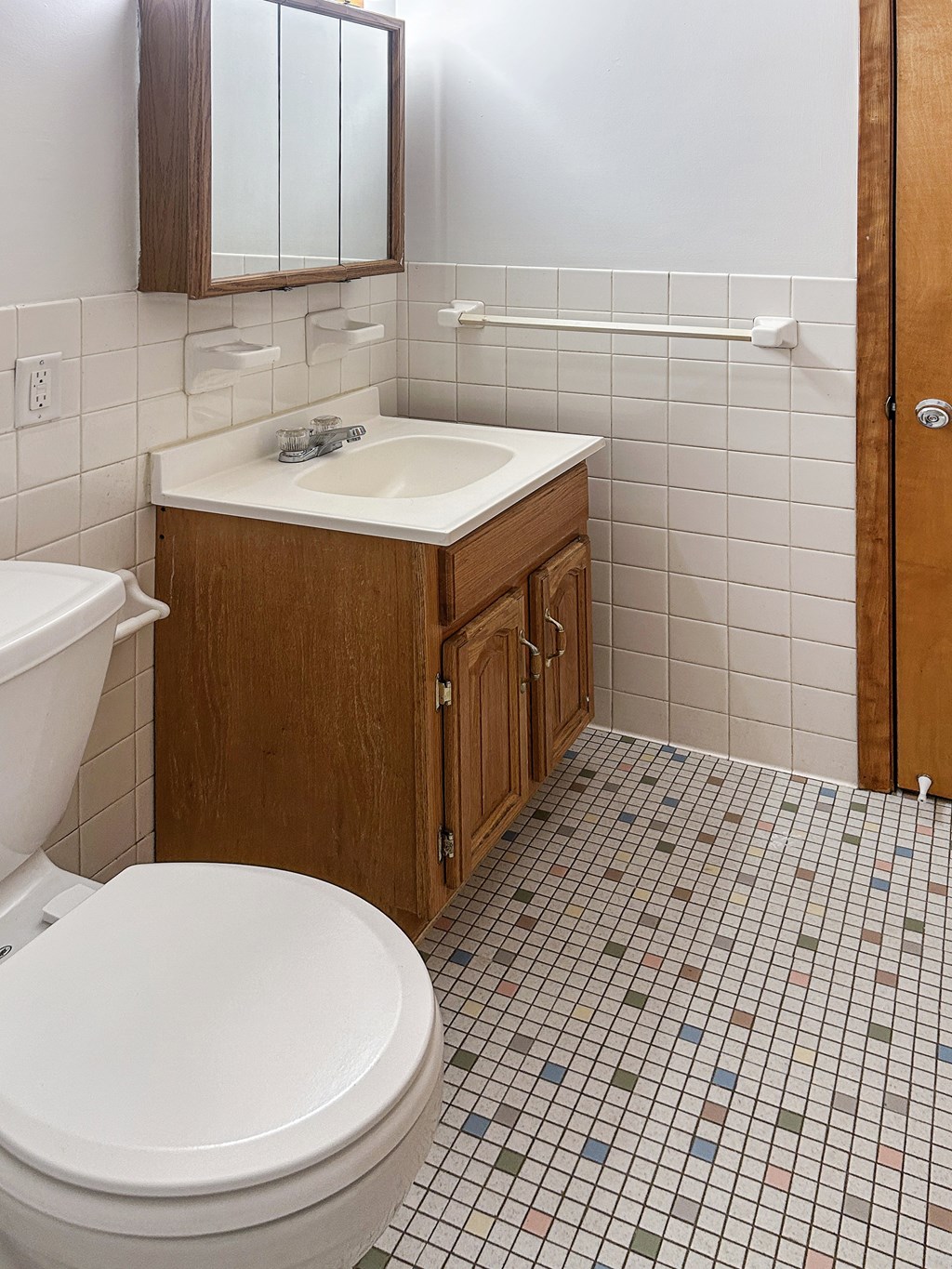 A white toilet sits next to a sink in a small bathroom.
