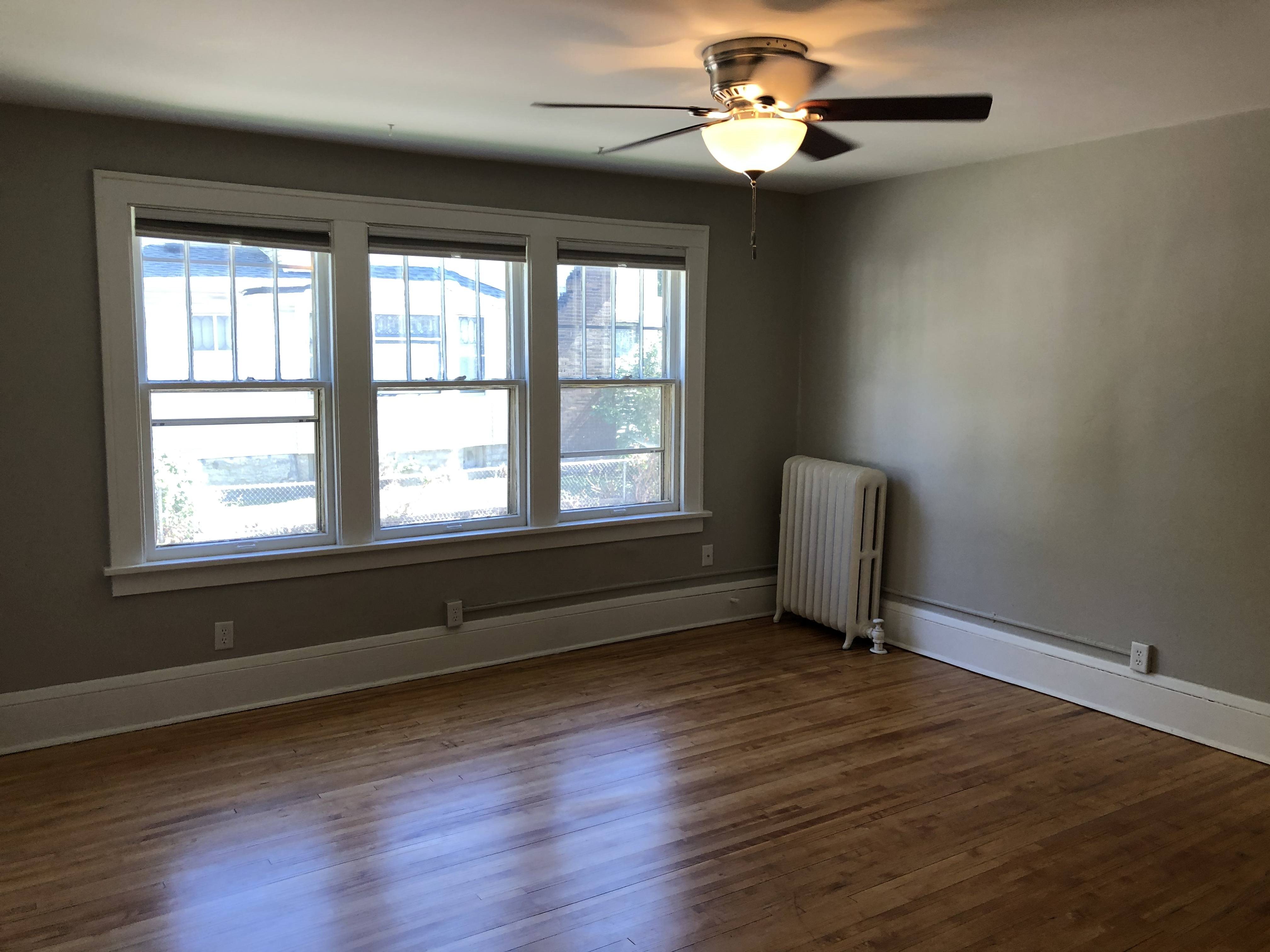 A room with a ceiling fan and a window.