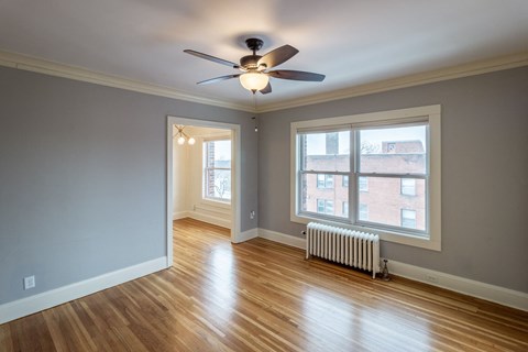 A room with a ceiling fan and a window.
