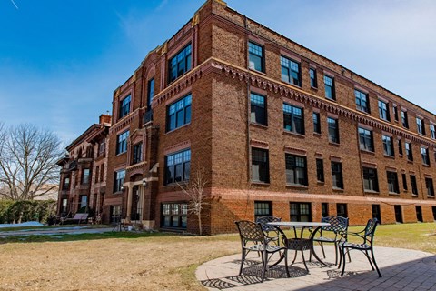 A red brick building with a table and chairs outside.