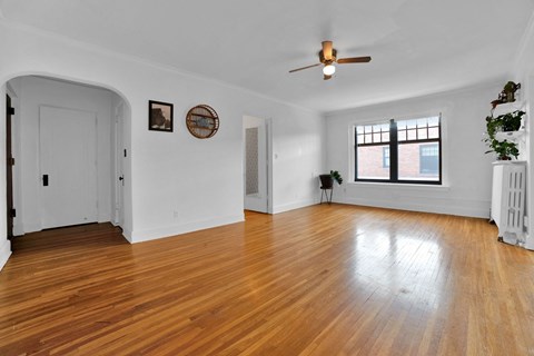 A room with a wooden floor and a ceiling fan.