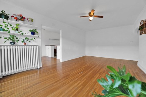 A room with wooden floors and a ceiling fan.