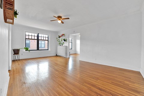 A room with wooden floors and a ceiling fan.