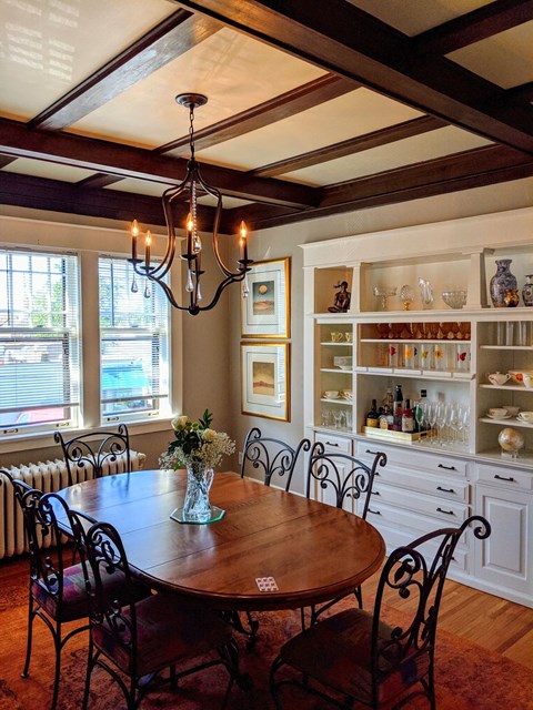 A dining room with a wooden table and chairs.