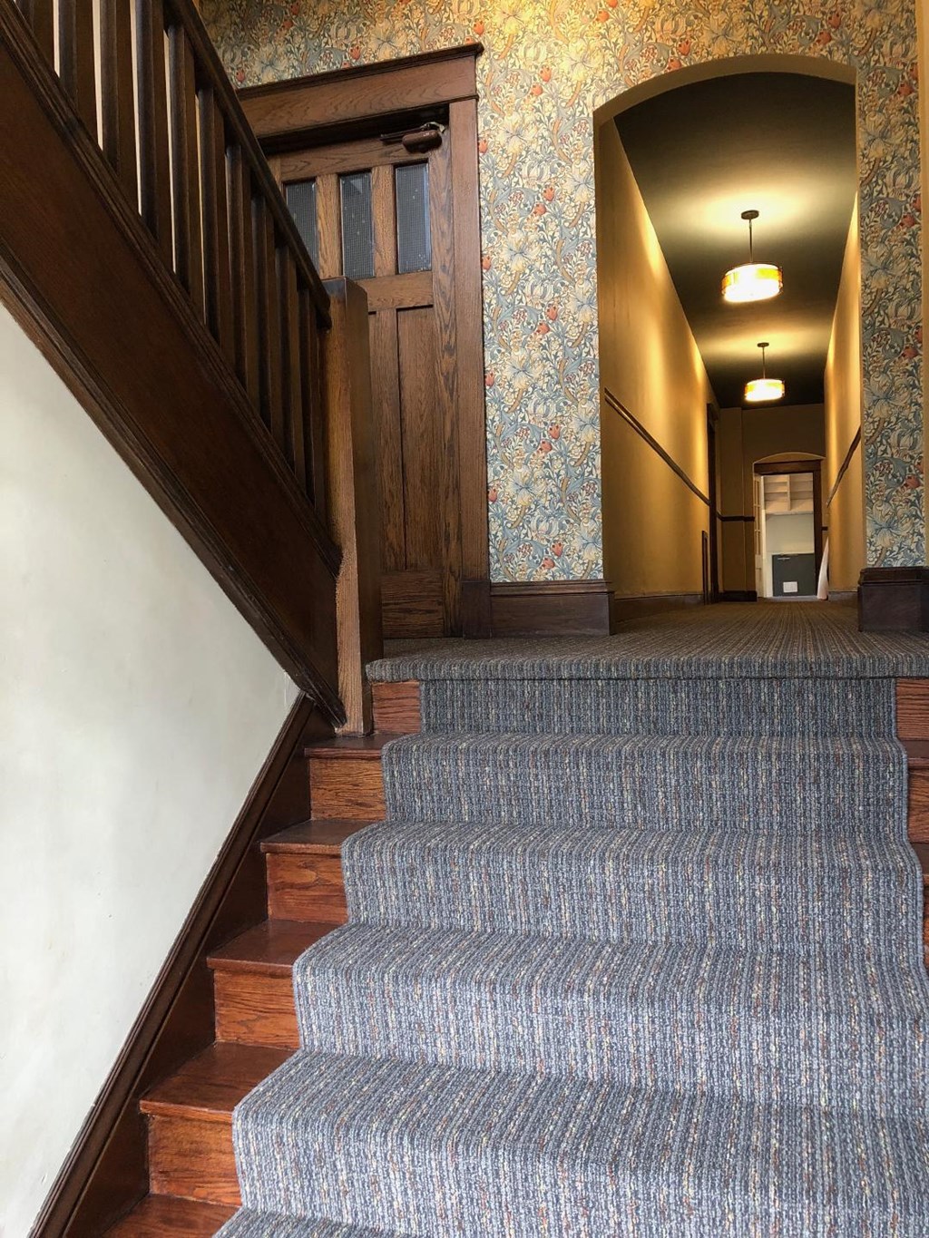 A staircase with a carpeted runner and wooden steps.