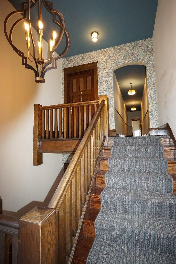 A staircase with a light blue carpet and wooden railings.