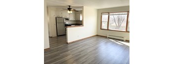 A kitchen with a refrigerator, cabinets, and a ceiling fan.