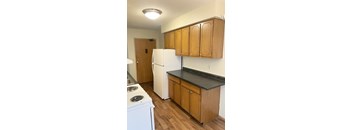 A kitchen with wooden cabinets and a white fridge.