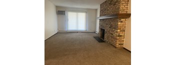 A room with a fireplace and a window with blinds.