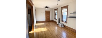 A room with wooden floors and a ceiling fan.