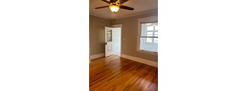 A room with a ceiling fan and a door.