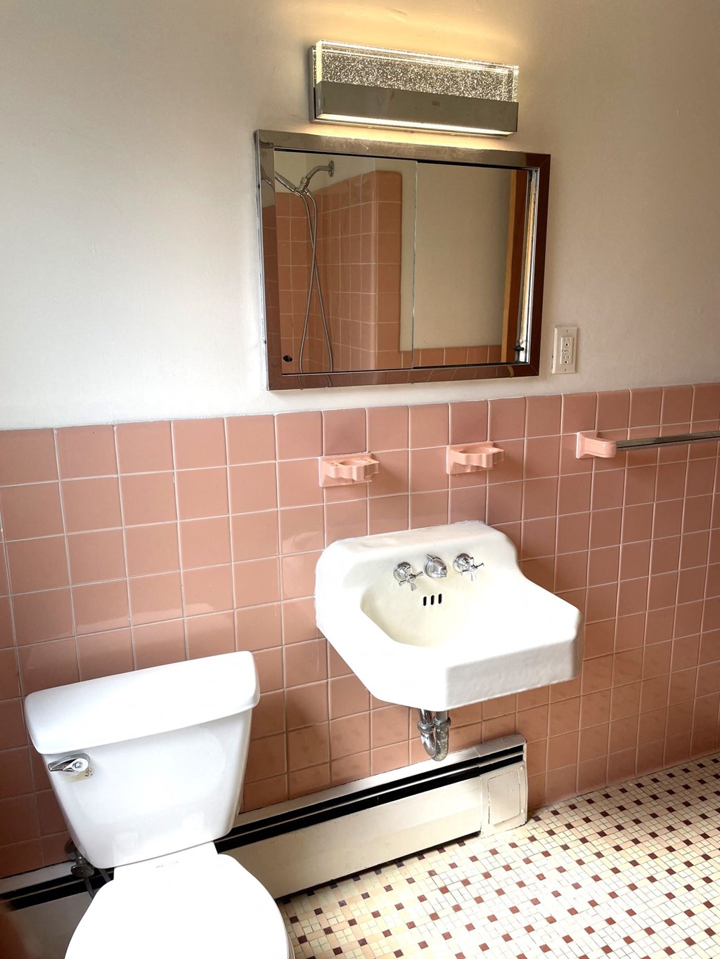 A white toilet sits next to a sink in a bathroom.