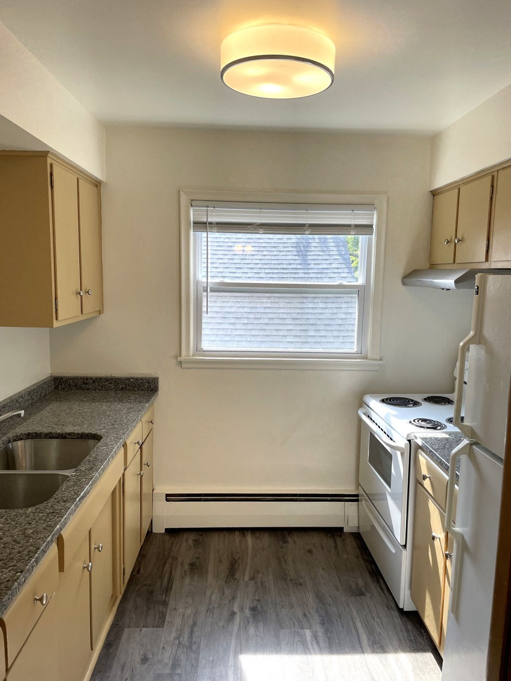 A kitchen with a stove, sink, and cabinets.