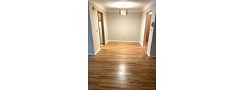 A room with wooden floors and a light hanging from the ceiling.