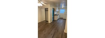 A room with a ceiling fan and wooden flooring.